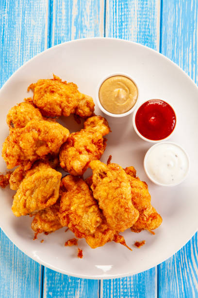 istock Fried chicken nuggets on blue wooden background 1193843812