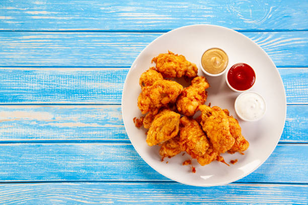 istock Fried chicken nuggets on blue wooden background 1193843831