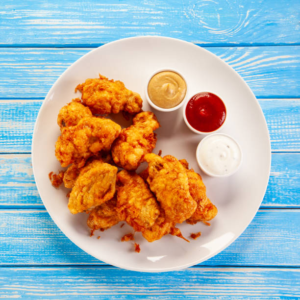 istock Fried chicken nuggets on blue wooden background 1193843844