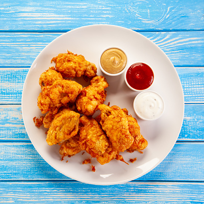 Fried chicken nuggets on blue wooden background