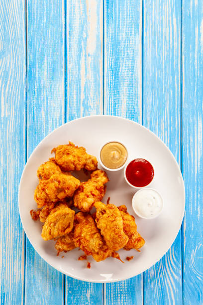 istock Fried chicken nuggets on blue wooden background 1193843860