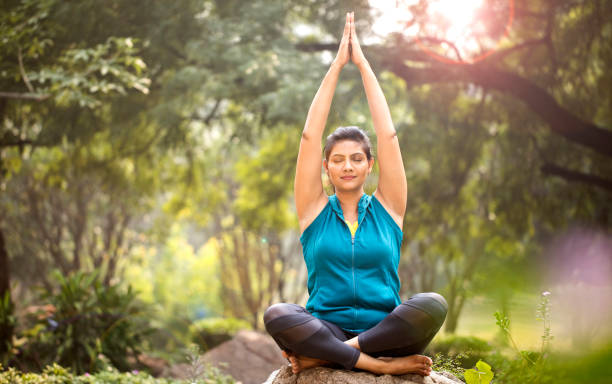 istock Beautiful woman meditating at park 1193844417