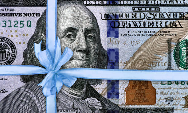 koncepcyjny obraz korzyści finansowych - currency perks gift bow zdjęcia i obrazy z banku zdjęć