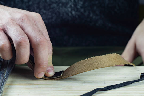 istock Craftsman Makes Genuine Black Leather Strap. Handmade Concept. Small business 1193848941