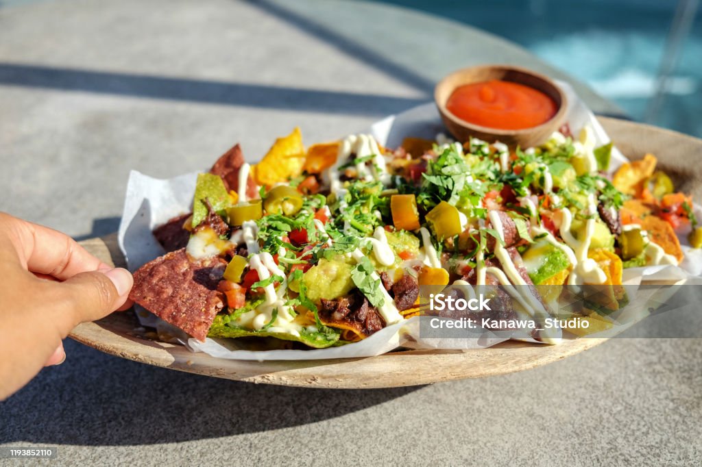 Young woman eating beef nachos Close up a single young women eating beef nachos Eating Stock Photo