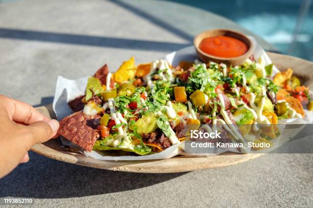 Young Woman Eating Beef Nachos Stock Photo - Download Image Now - Eating, Guacamole, Mexican Food