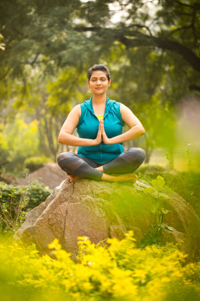 istock Beautiful woman meditating at park 1193858142