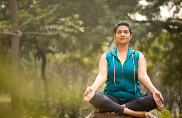 istock Beautiful woman meditating position at park 1193858241