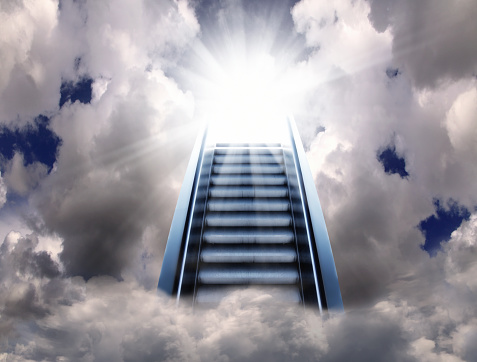 Conceptual success image of escalator stair way up to cloudy sky and shining sun with sunbeam