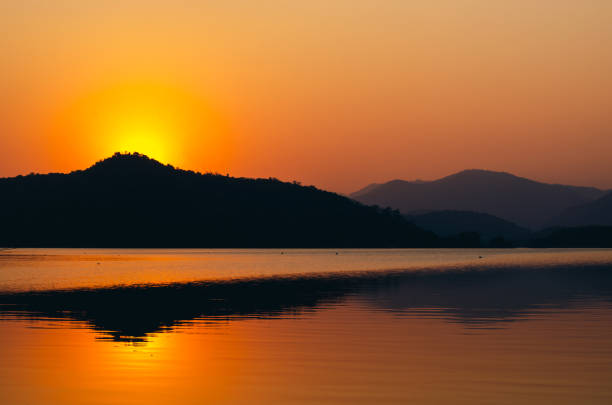 Free Stock Photo of The Sun Sets Over Mountains and Water | Download ...