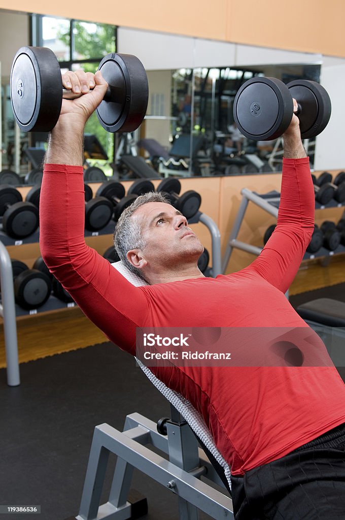 Uomo maturo sollevamento pesi - Foto stock royalty-free di Adulto