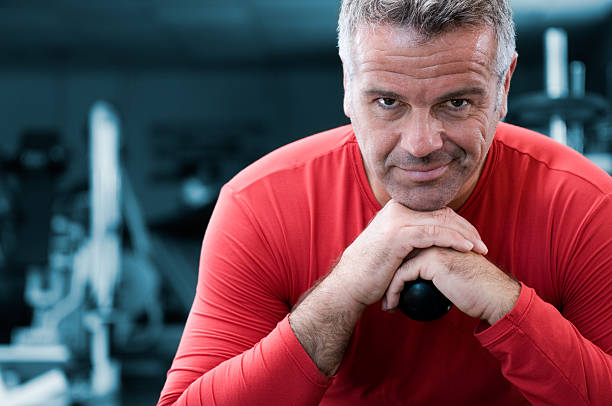Happy mature man standing in a health club and looking at camera.