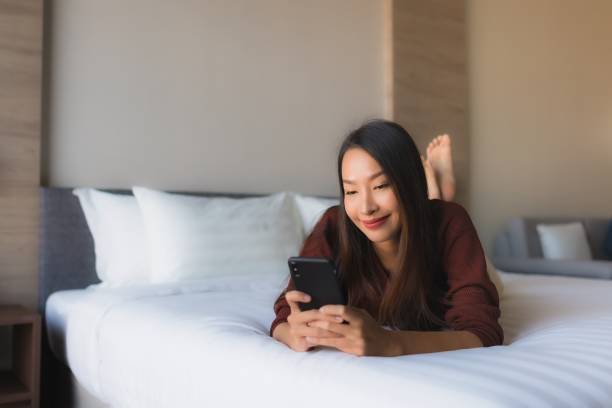 istock Portrait beautiful young asian women using mobile phone on bed 1193869452