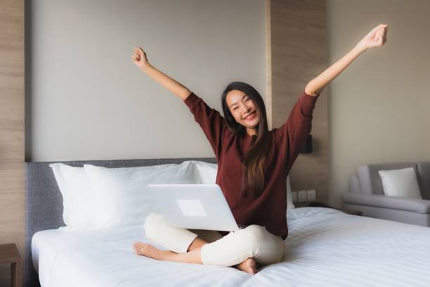 istock Portrait beautiful young asian women using computer and mobile phone on bed 1193870838