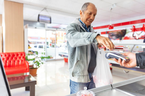 hombre mayor haciendo el pago sin contacto - red meat fotografías e imágenes de stock