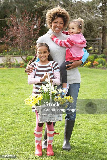 Foto de Mãe E Crianças Segurando Cesta De Narcisos No Jardim e mais fotos de stock de 30 Anos