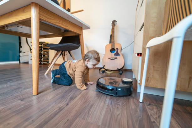 Young boy discovering vacuum robot stock photo