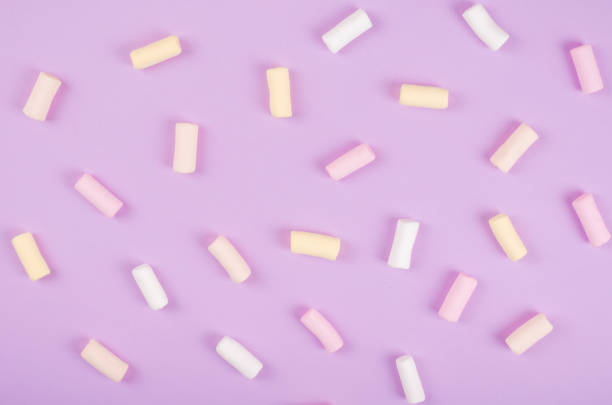 composição colorida do marshmallow no fundo roxo. deitada plana. - unhealthy eating copy space marshmallow softness - fotografias e filmes do acervo