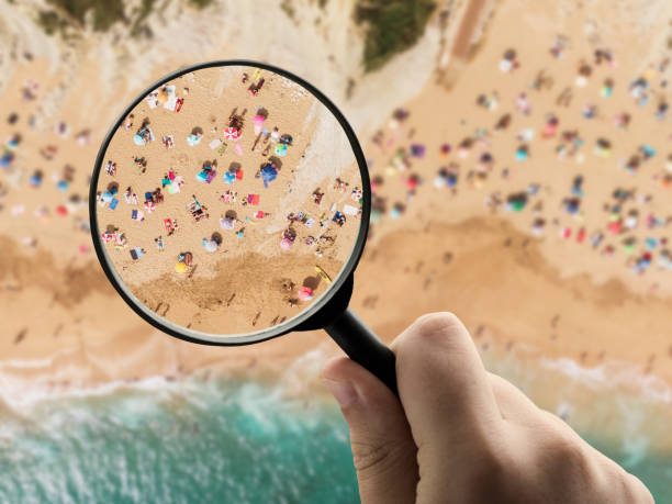istock Magnifying glass focusing on a crowded beach in summer 1193879017