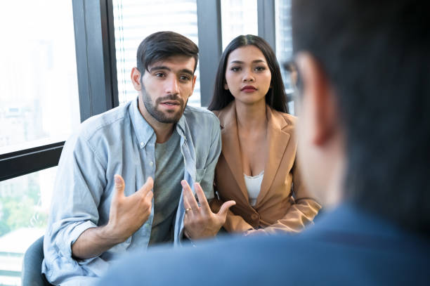 istock Psychotherapist inquiring about symptoms occurring within mind from patients with mental health problems in hospital. Group psychotherapy for support and helping worried man to change negative mindset 1193881395