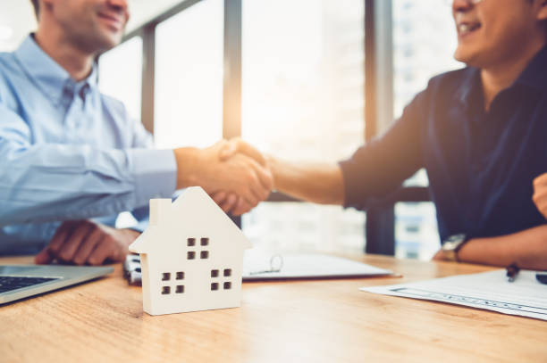 primo piano dell'agente di intermediazione immobiliare che stringe la mano al cliente dopo aver firmato con successo i documenti del contratto di contratto con la proprietà della casa. acquisto reale di proprietà. concetto di approvazione del mutuo ipote - apartment real estate agent real estate mansion foto e immagini stock