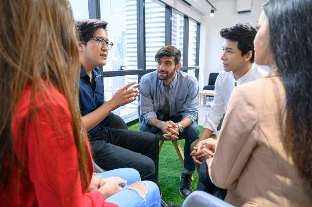 istock Psychotherapist inquiring about symptoms occurring within mind from patients with mental health problems in hospital. Group psychotherapy for support and helping worried man to change negative mindset 1193881479