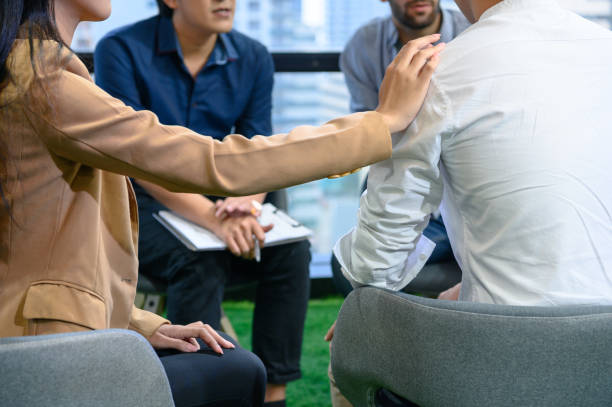 psicoterapeuta preguntando sobre los síntomas que ocurren en la mente de pacientes con problemas de salud mental en el hospital. psicoterapia grupal para apoyo y ayudar al hombre preocupado a cambiar la mentalidad negativa - drug abuse addiction women violence fotografías e imágenes de stock