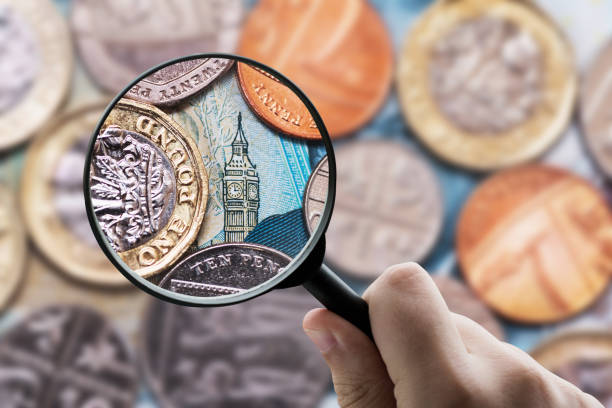 lente d'ingrandimento focalizzata sulla valuta della sterlina britannica (gbp) - currency british currency uk british coin foto e immagini stock