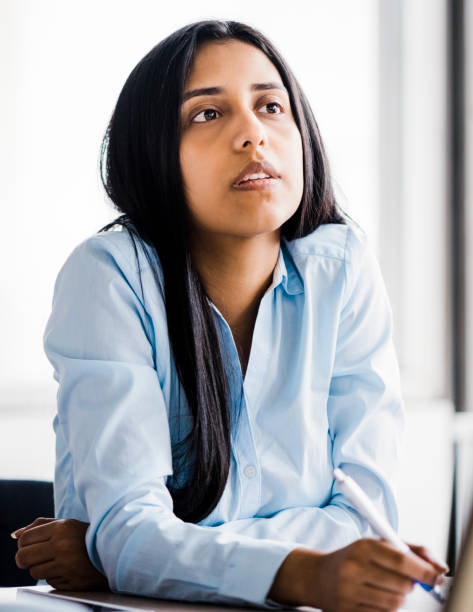 istock Businesswoman looking away while sitting in office 1193882323