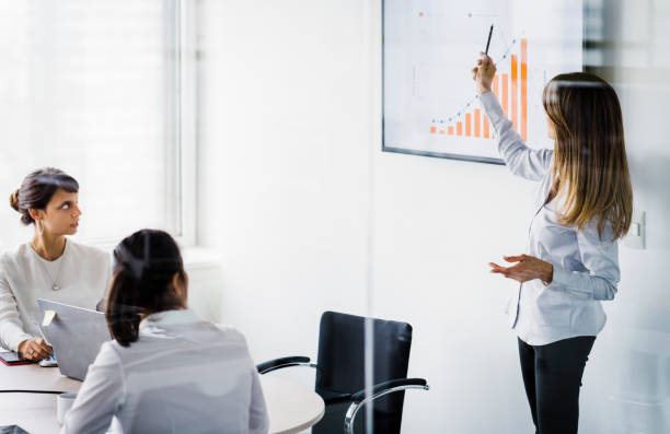 istock Businesswoman explaining colleagues over graph 1193882450