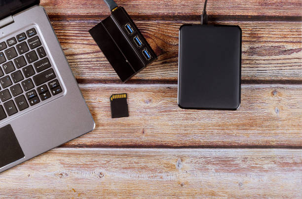 istock External backup disk hard drive connected to laptop computer transfer photos to SD cards photographer's desktop workspace 1193894314