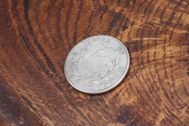 istock old vintage silver dollar on wooden background 1193894373
