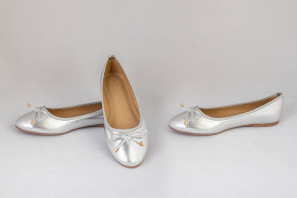 istock Ladies silver reflective flat shoes on white background 1193894453