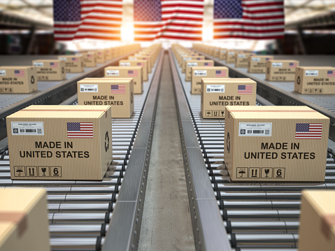 Hecho en Estados Unidos. Cajas de cartón con texto hecho en EE.UU. y bandera americana en el transportador de rodillos. photo