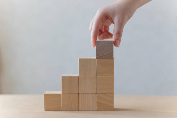 istock Hand arranging wood block stacking as step stair on table. Business concept for growth success process. 1193899481