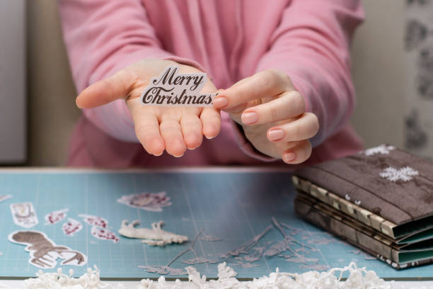 women's hands are holding a inscription paper ðerry cristmass. scrapbooking. - scrap metal audio imagens e fotografias de stock