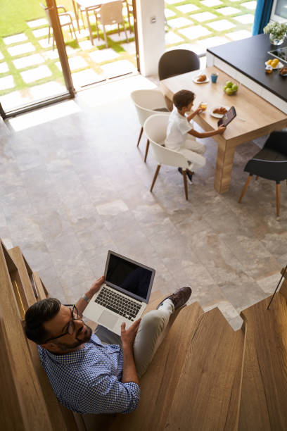 istock Happy father and his son sitting with gadgets st home 1193904388