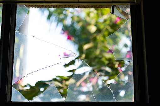 Looking through broken glass window.