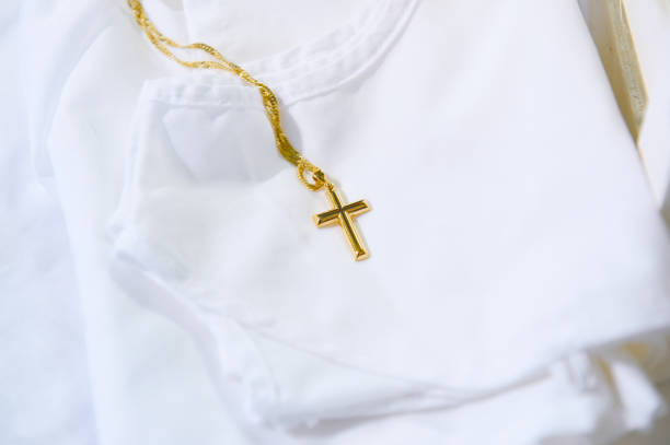 Gold Cross on White Baby Shirt stock photo