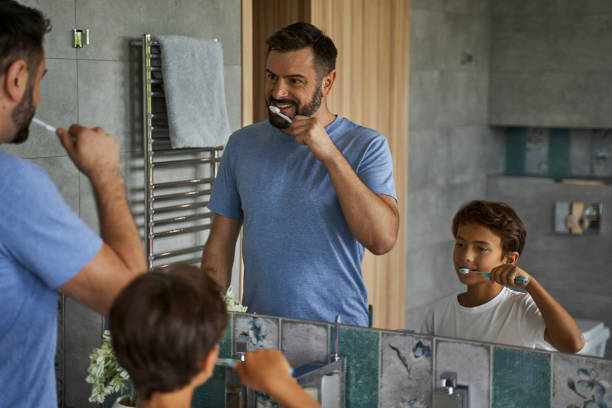 istock Smiling man and his child standing in bathroom 1193907084