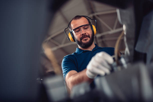istock Factory worker operating band saw cutting machine 1193907107
