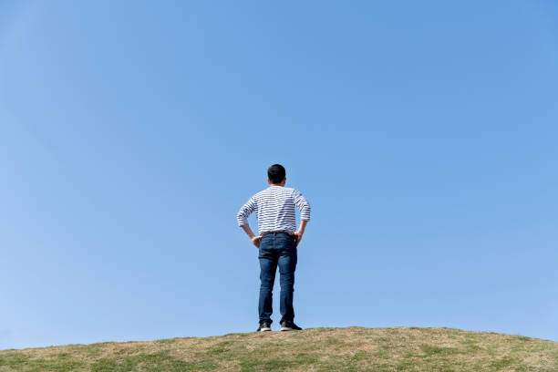 istock Man standing on meadow with arms akimbo 1193907984