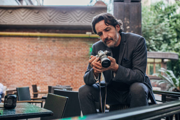 istock Elegant businessman looking at photos on digital camera 1193908211