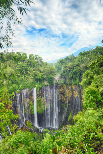(afbeelding met hoog dynamisch bereik) verbluffende luchtfoto van de tumpak sewu watervallen ook bekend als coban sewu met de semeru vulkaan in de verte, malang regency, oost-java, indonesië. - malang stockfoto's en -beelden