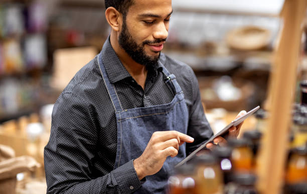 istock Employee working at the bio grocery shop, using digital tablet 1193909900