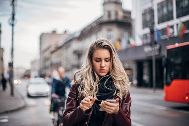 istock Pretty young woman is text messaging 1193910304