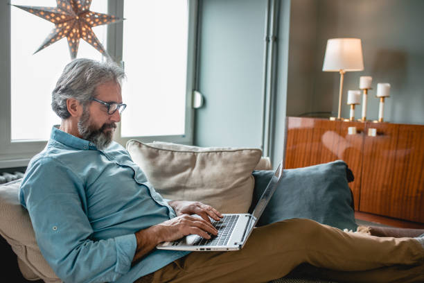 istock Senior man using laptop at home 1193910512