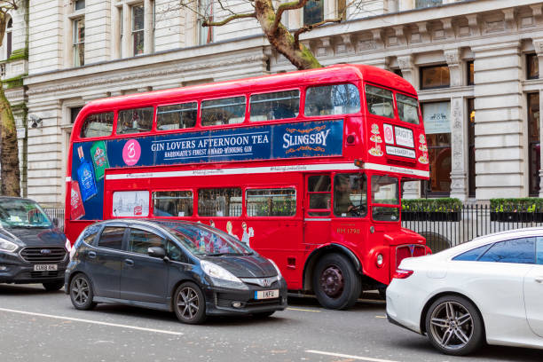 London, UK - Dec 11, 2019: Iconic, classic red double decker bus driving, turning on intersection with people sitting, eating during Afternoon Tea Tour