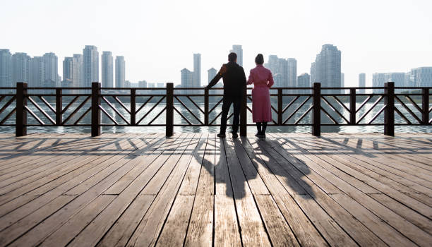 Couple standing on boardwalk by the sea.