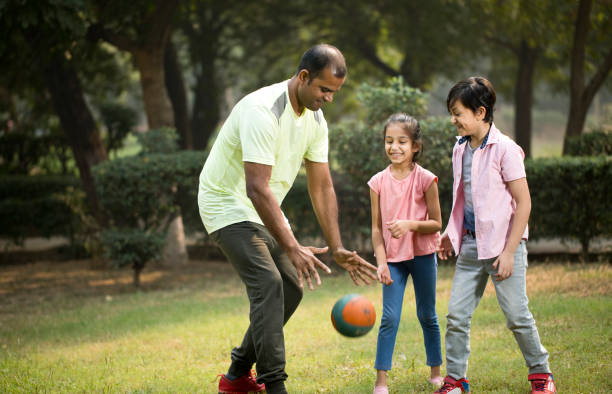 istock Family playing with ball at park 1193913677
